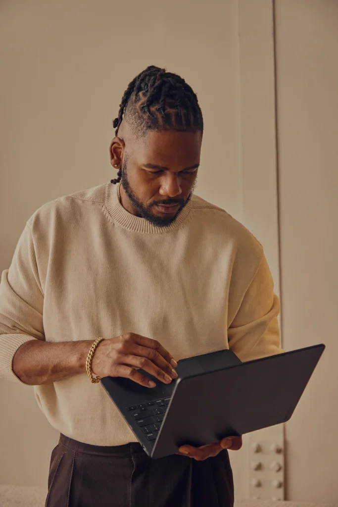 Brandon standing and working on a laptop